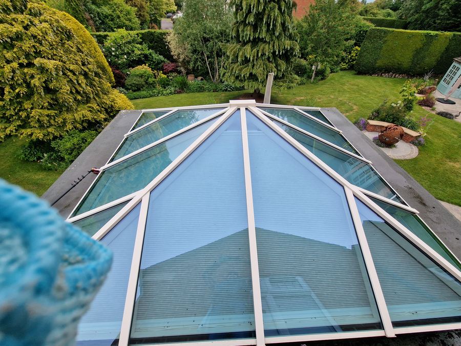 Glass conservatory roof cleaned, overlooking a garden