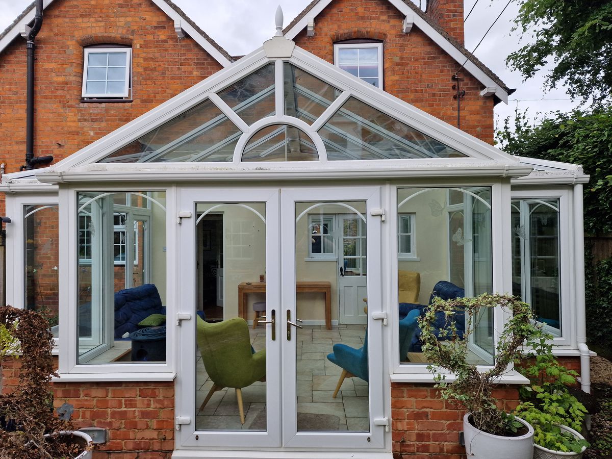 Conservatory roof and frames cleaned on a red-brick house
